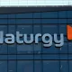 Exterior view of a modern glass building with a large 'Naturgy' sign and the orange logo on the facade