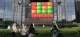 Pedestrians walk past a stock market display board in Jakarta
