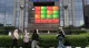 Pedestrians walk past a stock market display board in Jakarta